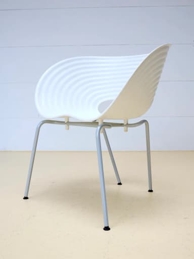 A modern white molded chair featuring a distinct wavy, ridged surface texture and a unique cutout in the seat. It is supported by slender metal legs. — 3D model