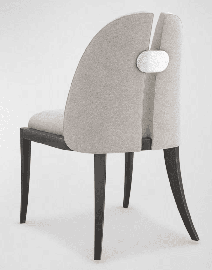 A contemporary dining chair featuring a light gray upholstered seat and a distinctive curved, split backrest. The backrest halves are joined by a decorative, textured silver-toned metallic accent piece. The chair is armless and supported by four dark, tapered wooden legs, with the rear legs exhibiting a slight curve. The overall design suggests a modern and elegant aesthetic. — 3D model