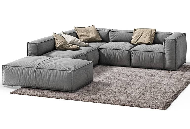 A contemporary modular sectional sofa upholstered in grey fabric, featuring deep, soft cushions and a matching ottoman. The design emphasizes comfort and flexibility, with distinct seams defining the individual modules. — 3D model
