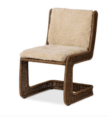 A chair with a rattan or wicker frame and upholstered seat and backrest with a sheepskin or faux sheepskin material. The frame has a woven texture. It features a low shelf or footrest integrated into the base, also constructed from woven material. — 3D model