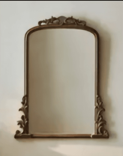 A freestanding cheval mirror featuring an arched top and an elaborately carved dark brown wooden frame. The frame exhibits intricate scrollwork and decorative motifs along its top curve and base, suggesting a traditional or baroque-inspired design. The mirror glass is clear, offering a full-length reflection. — 3D model