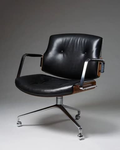 An executive-style swivel chair featuring black leather upholstery, a curved wooden shell, and a polished metal base. The seat and backrest are padded and tufted, providing a comfortable appearance. The armrests are made of chromed metal with black upholstered pads. The chair sits on a five-star wheeled base, indicative of an office or desk chair. — 3D model