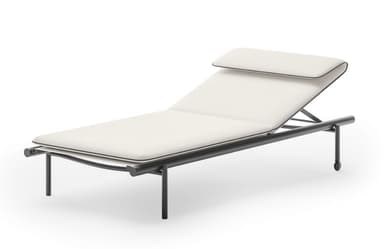 A modern chaise lounge with a sleek, minimalist design. It features a thin, rectangular frame supporting a padded mattress and a separate headrest. The frame is constructed from dark-colored metal, and the upholstery is a light, neutral color with thin, contrasting piping along the edges. One end of the frame has small wheels for mobility. — 3D model