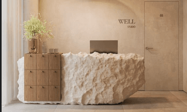 A contemporary reception desk or service counter, featuring a wooden cabinet section with multiple drawers or doors on one side, and a large, rough-textured, organic-shaped block forming the main body and extension. The top surface of the wooden section serves as a flat countertop, adorned with decorative items. — 3D model