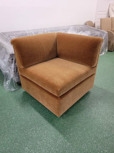 An upholstered corner module for a sectional sofa, featuring a low profile and plush fabric, designed to connect with other pieces to form a larger seating arrangement. — 3D model
