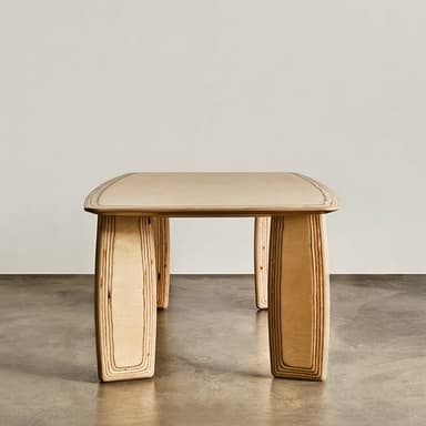 A rectangular dining table crafted from light-colored plywood, featuring a smooth tabletop with gently rounded corners and thick, curved slab-like legs that display the layered construction of the wood. — 3D model