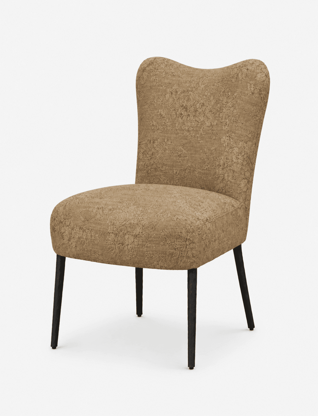 An armless upholstered chair featuring a camel-colored fabric with an intricate, darker patterned motif. The chair has a gently curved backrest, somewhat resembling a subtle wingback or shell shape. It is supported by four slender, slightly splayed, textured dark metal legs. — 3D model