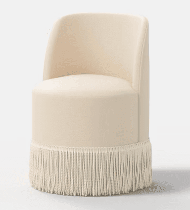 A cream-colored, cylindrical upholstered accent chair featuring a low, curved backrest and a distinctive fringe detail around its base. — 3D model