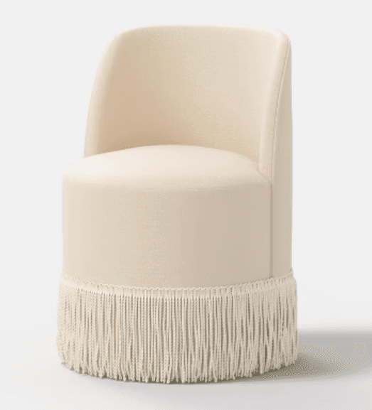 A cream-colored, cylindrical upholstered accent chair featuring a low, curved backrest and a distinctive fringe detail around its base. — 3D model