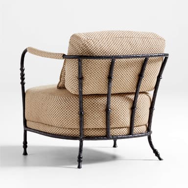 A comfortable lounge chair featuring a dark, textured forged iron frame with decorative baluster-like turnings on the uprights and legs. The armrests are partially wrapped in a contrasting natural rope material. The seat, backrest, and a lumbar pillow are upholstered in a tightly woven, checkered fabric with beige and brown tones. — 3D model