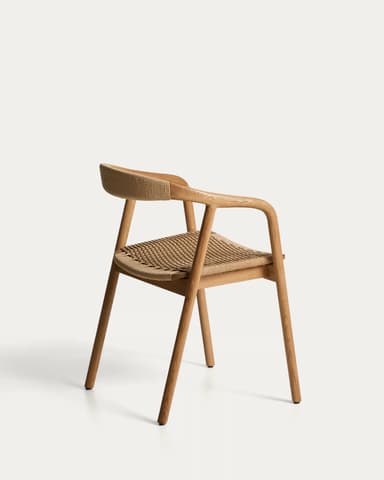 A modern dining chair with a curved backrest and a woven seat. The frame is constructed from light-colored wood, possibly oak, with a natural finish. The seat and backrest are made of a tightly woven natural fiber material, likely rattan or a similar cane, giving it a textured appearance. The chair has four legs, with the front legs being straight and the back legs appearing to extend upwards to form the chair's arms and support the backrest. The design is minimalist and ergonomic, emphasizing natural materials and clean lines. — 3D model