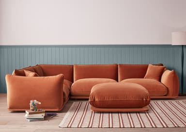 A light sage green modular sectional sofa featuring a low-profile base and plush, rounded upholstered cushions. The sofa is arranged in an L-shape configuration, accompanied by a matching square ottoman placed in front. The design emphasizes comfort and a minimalist contemporary aesthetic, with soft lines and a cohesive color palette. — 3D model
