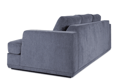A contemporary upholstered sofa, viewed from the rear-right angle, featuring clean lines and a substantial form. It is covered in a textured slate gray fabric, presenting a modern aesthetic. The design includes thick, squared-off track arms and loose, plush back cushions. The sofa sits on a recessed plinth base, giving it a slightly floating appearance. The overall condition appears new and well-maintained. — 3D model