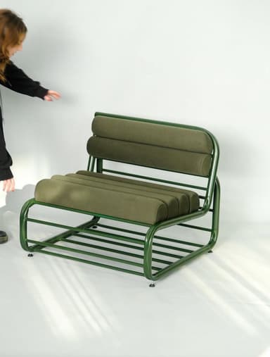 A modern lounge chair featuring a bent tubular steel frame and bolster-style cushions, all finished in a monochromatic forest green color. — 3D model