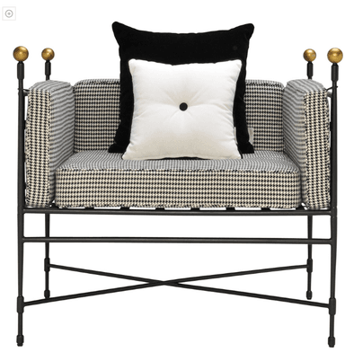 A bench with a dark metal frame and a cushioned seat upholstered in a black and white houndstooth pattern fabric. The backrest is also upholstered with the same fabric and features a grid-like design formed by dark straps. Two spherical finials are visible at the top of the backrest on the left side. — 3D model