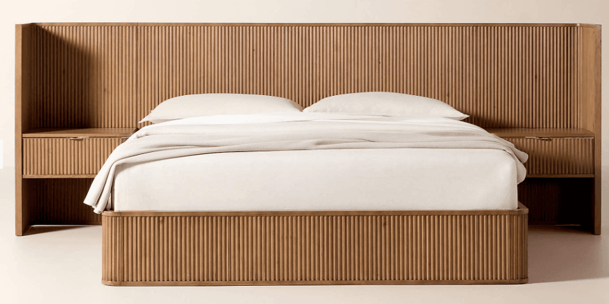 A wooden bed frame featuring a tall, slatted headboard that extends outwards to form integrated nightstands on either side. The bed frame itself is also constructed with slatted panels around its base. The nightstands have drawers with ribbed fronts and thin, possibly metallic, drawer pulls. The overall design is modern with a focus on linear textures. — 3D model