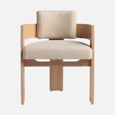 A modern accent chair featuring a distinctive T-shaped oak wood frame and integrated curved backrest/armrests, upholstered with cream bouclé fabric cushions. — 3D model