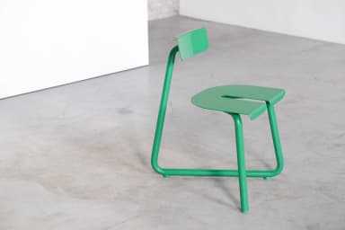 A bright green contemporary chair featuring a minimalist design. It has a distinctive U-shaped seat and a small rectangular backrest, both constructed from continuous tubular metal. The entire frame is finished in a uniform, glossy green. — 3D model