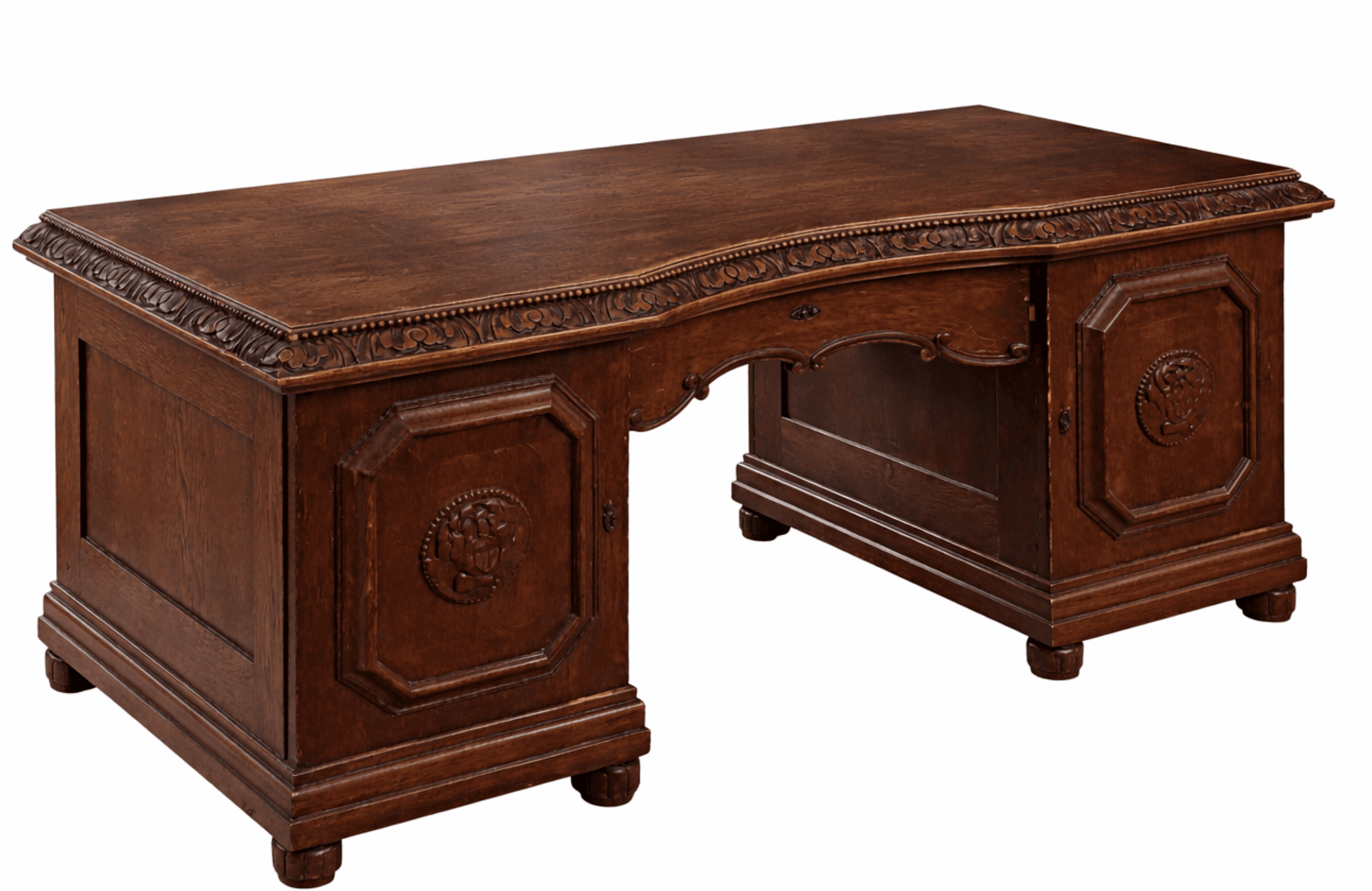 A traditional wooden desk with a curved top edge. It features ornate carvings along the top trim and on the panels of its base. The desk has a central kneehole area with decorative scrollwork, and it rests on four bulbous feet. There is a visible drawer pull in the center. — 3D model