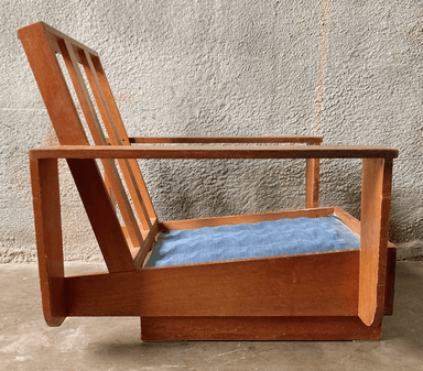 A wooden armchair with a slatted backrest and a light blue upholstered seat cushion. The armchair features a minimalist design with clean lines and a natural wood finish. — 3D model