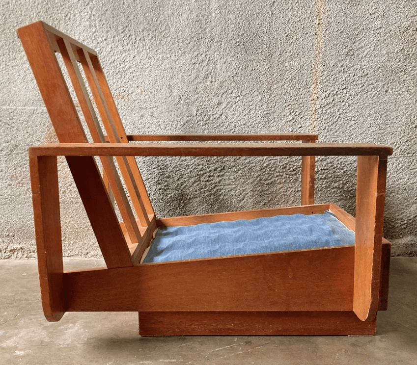 A wooden armchair with a slatted backrest and a light blue upholstered seat cushion. The armchair features a minimalist design with clean lines and a natural wood finish. — 3D model