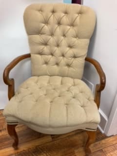 A tufted armchair with a high back and wooden armrests. The chair has a classic design with carved wooden legs. — 3D model