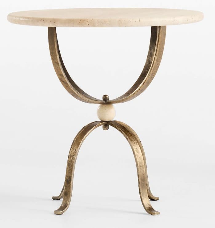 A round side table featuring a creamy travertine top and a sculptural base made of hammered, antique brass-finished metal, accented by a central spherical element. — 3D model