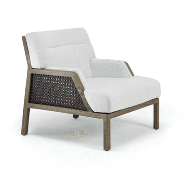 A modern armchair featuring a robust wooden frame with intricate woven cane panels on its sides. The chair is upholstered with thick, comfortable cushions in a light, textured fabric, providing a contrast to the natural wood and dark cane. The overall design emphasizes clean lines and a relaxed aesthetic. — 3D model