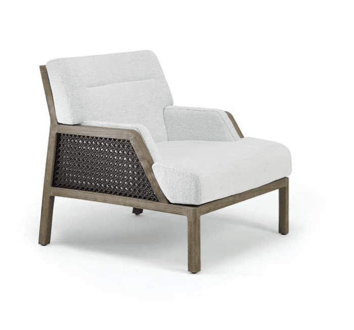 A modern armchair featuring a robust wooden frame with intricate woven cane panels on its sides. The chair is upholstered with thick, comfortable cushions in a light, textured fabric, providing a contrast to the natural wood and dark cane. The overall design emphasizes clean lines and a relaxed aesthetic. — 3D model