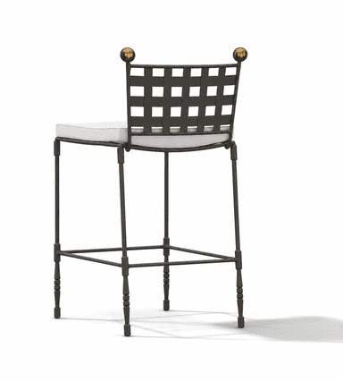 A tall bar stool featuring a dark wrought iron frame with a distinctive woven grid backrest and two spherical brass finials. The seat is cushioned and upholstered in a light-colored fabric, likely off-white or cream. The legs are slender, with some turned details towards the bottom, and include a square footrest for support. — 3D model
