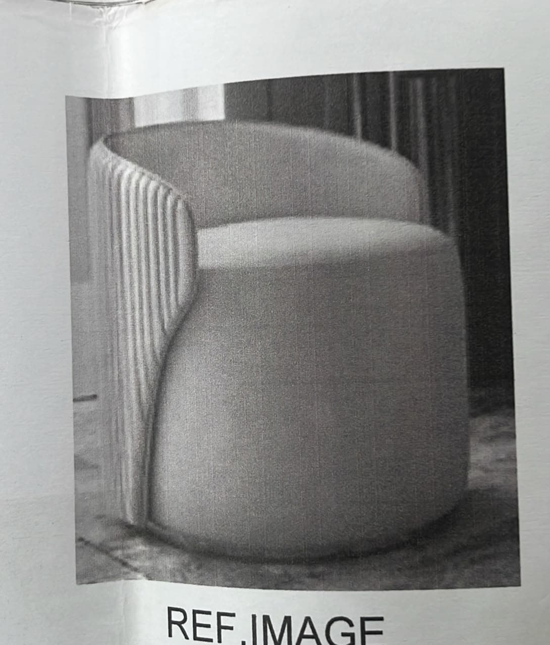 A modern, barrel-shaped accent chair upholstered in a light gray fabric. The chair features a distinctive fluted or ribbed exterior on its rounded backrest, which seamlessly transitions into integrated armrests. The seat cushion is well-padded and the chair sits on a low, fully upholstered base, giving it a monolithic and sculptural appearance. Its rounded silhouette contributes to a soft, inviting aesthetic. — 3D model