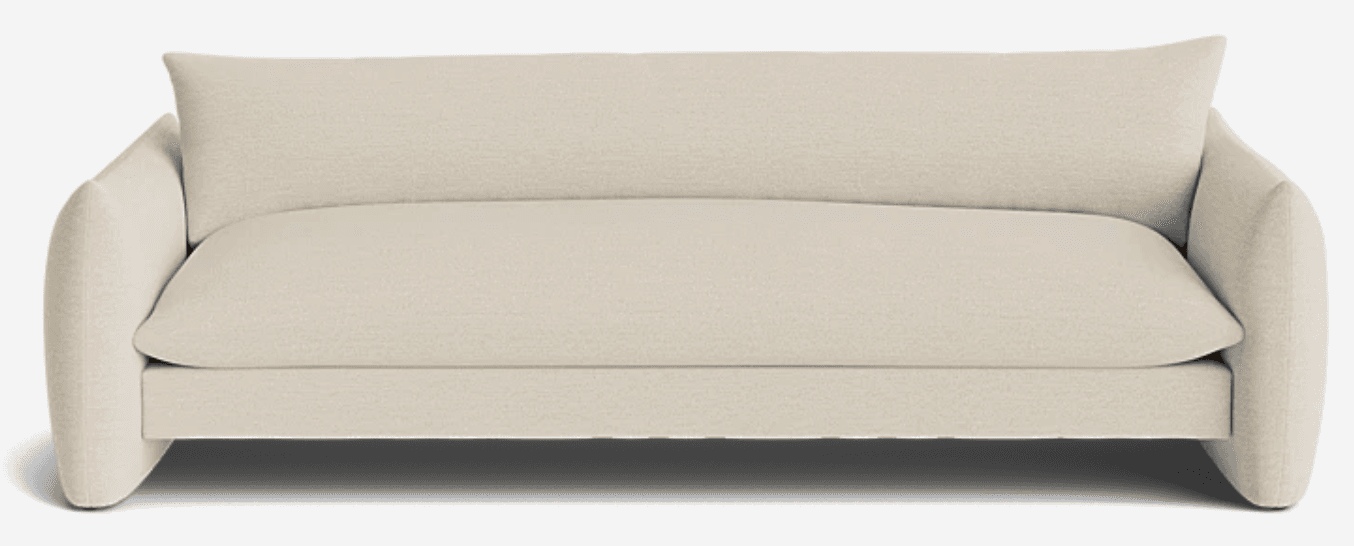 A contemporary upholstered sofa featuring a soft, light beige fabric. The design is characterized by its wide, rounded arms that extend seamlessly to the floor, creating a cohesive and minimalist profile. It has a single, plush seat cushion and a matching single back cushion, suggesting a comfortable and inviting aesthetic. The overall form is low-slung and modern, suitable for a relaxed living space. — 3D model