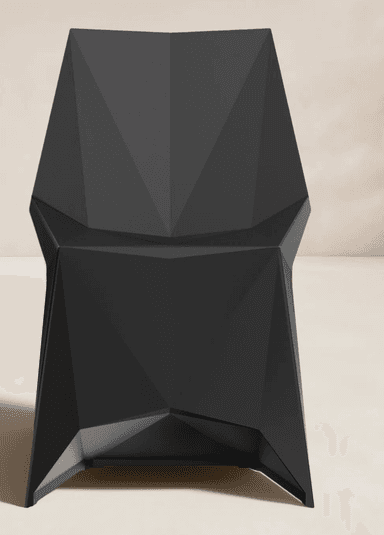 A striking contemporary chair featuring a highly geometric and faceted design, rendered in a matte black finish. Its form is composed of sharp angles and planar surfaces, creating a sculptural aesthetic. The seat, backrest, and integrated armrests flow seamlessly from a complex, angular base, giving it a monolithic appearance. — 3D model