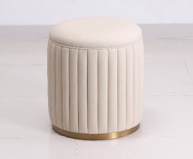 A modern, cylindrical upholstered ottoman featuring vertical fluting around its body and a smoothly padded, flat top. It rests on a polished brass-toned metallic base, presenting a luxurious and contemporary aesthetic. — 3D model