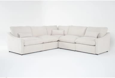 A cream-colored modular sectional sofa upholstered in a soft fabric, featuring plush cushions and a low-profile design, arranged in an L-shape. — 3D model