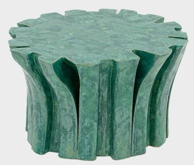A sculptural pedestal table featuring an organic, biomorphic design and a rich green finish. The table has a circular top with an irregularly scalloped edge, resembling a stylized leaf or natural formation. The base is composed of undulating, vertical elements that create a fluted or pleated effect, giving the piece a fluid and naturalistic appearance. The surface has a mottled, textured patina, suggesting either a ceramic, concrete, or composite material with a malachite-inspired glaze or finish. — 3D model