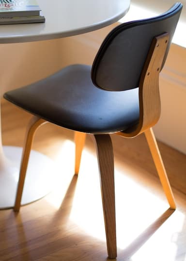 A modern dining chair featuring a curved bentwood frame and upholstered seat and backrest. The chair has four splayed, tapered wooden legs. — 3D model