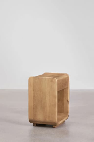 A modern, cube-shaped nightstand with rounded edges and an open compartment. The piece is constructed from solid wood and exhibits a natural grain pattern. It rests on a small, subtle base. — 3D model