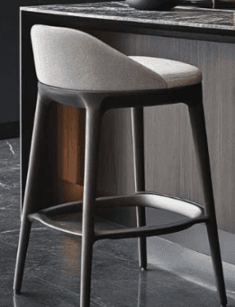 A modern bar stool featuring a light gray upholstered seat and a gently curved low backrest, supported by four dark brown tapered legs with an integrated circular footrest. — 3D model