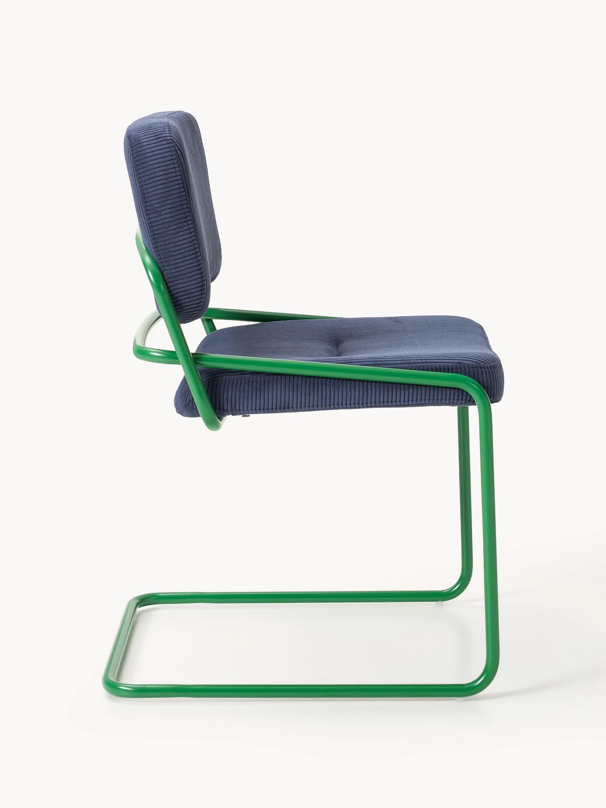 A side profile view of a modern accent chair. The chair features a tubular metal frame, painted in a vibrant green, forming cantilevered legs and armrests. The seat and backrest are upholstered in a navy blue corduroy fabric with a ribbed texture. The seat is slightly tufted. — 3D model