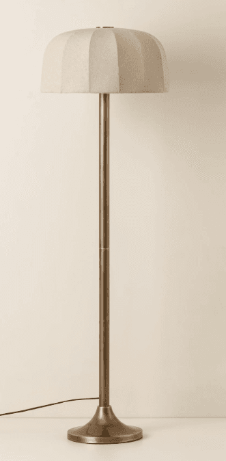 A floor lamp with a cylindrical metal pole and a bell-shaped lampshade. The lampshade has a textured fabric cover with vertical seam details. The base is a flared, circular metal stand. — 3D model