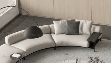 A modern, modular curved sectional sofa upholstered in light off-white fabric. The sofa features a sweeping curved form, composed of multiple sections including a chaise lounge element at one end. It is supported by a slender, minimalist black metal frame that extends to small, discreet legs. An integrated dark-colored side table or console is positioned at the opposite end of the sofa, providing a functional surface. The seating is complemented by loose back cushions in matching off-white, along with a contrasting dark grey throw pillow. — 3D model