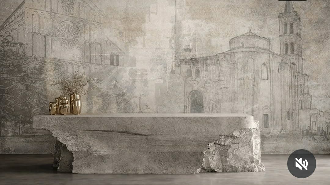 A large, monolithic console table crafted from concrete, designed with a sculptural, brutalist aesthetic. It features a wide, flat top surface supported by a rugged, irregular base that mimics the appearance of raw, broken stone or rock. The texture is coarse and uneven, highlighting its material properties. — 3D model