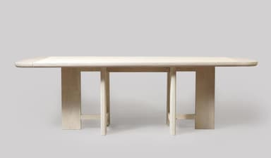A rectangular dining table crafted from light-colored wood, featuring a slatted top with gently rounded corners. The table is supported by two distinct trestle-style bases, each composed of two vertical elements braced by a horizontal stretcher near the floor. The wood exhibits a bleached or limed finish, emphasizing its grain and contributing to a minimalist aesthetic. — 3D model
