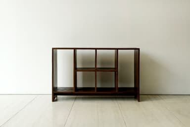 A dark brown wooden shelving unit with multiple open compartments, featuring a solid construction and varying shelf configurations. — 3D model