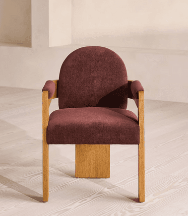 A modern armchair featuring a sturdy wooden frame and rich burgundy upholstery. The design incorporates solid, block-like wooden armrests and legs, with a gently curved, upholstered backrest and seat. The armrests also have padded cushions for added comfort. — 3D model
