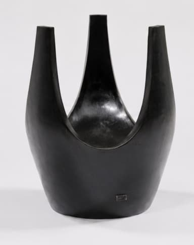 A dark, U-shaped sculptural stool, likely crafted from patinated bronze or ebonized wood. Its form is fluid and organic, with a deep, curved seat integrated into the continuous structure. The material exhibits a smooth, subtly reflective finish. — 3D model