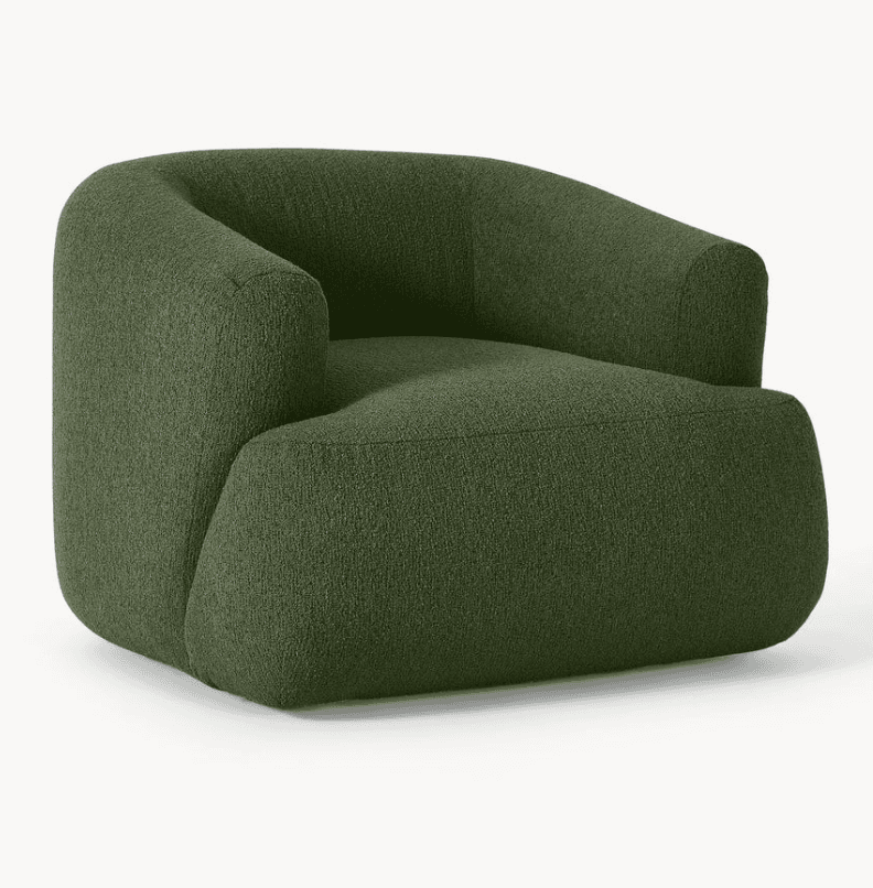 A contemporary armchair with a rounded, sculptural design. It features a deep seat, integrated armrests that curve into the backrest, and a solid base. The upholstery has a textured, boucle-like finish. — 3D model