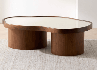 An organic modern coffee table featuring a kidney-shaped top with a light-colored surface, supported by two dark brown cylindrical drum bases. — 3D model