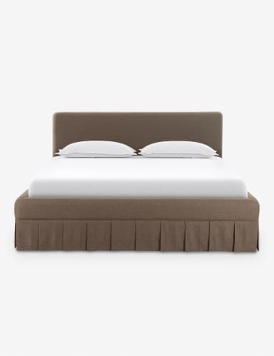 A contemporary upholstered platform bed featuring a soft, rounded headboard and a matching base with an integrated pleated bed skirt. The bed is rendered with a white mattress and two white pillows, suggesting a complete sleep system. The upholstery has a textured, fabric appearance in a neutral brown or taupe color. — 3D model
